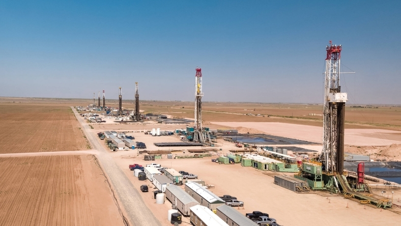 Multiple oil and gas rigs at active drilling site